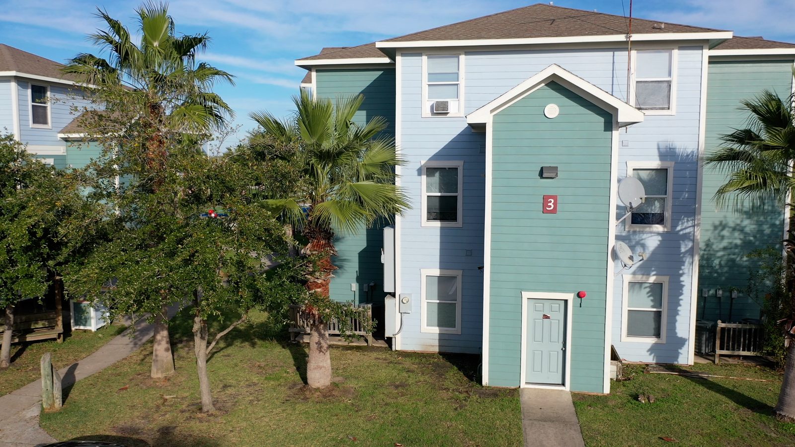 Exterior of a UAG apartment building with palm trees