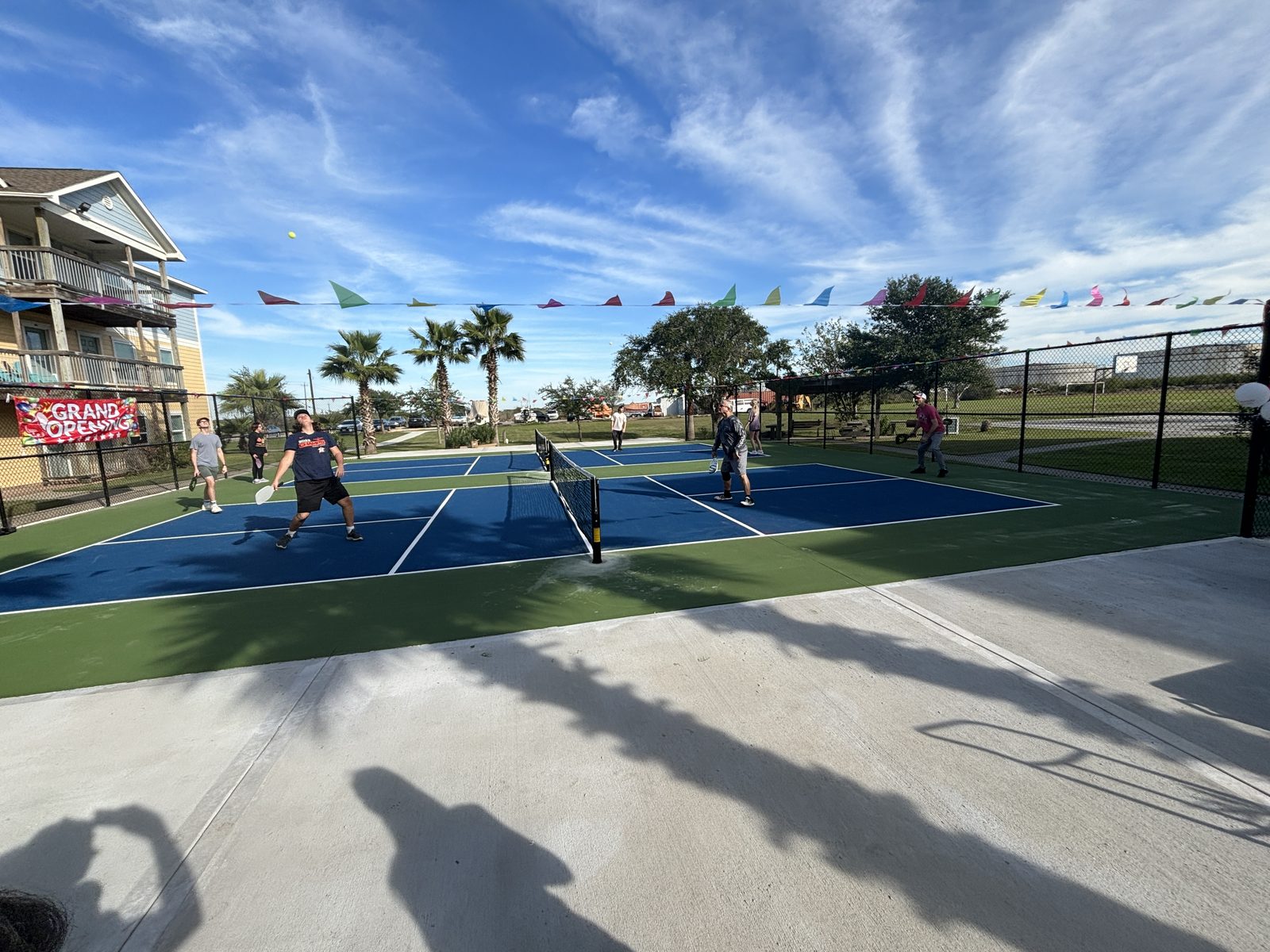 Empty pickleball courts beneath a blue sky