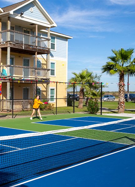 Residents playing pickleball between the apartment buildings